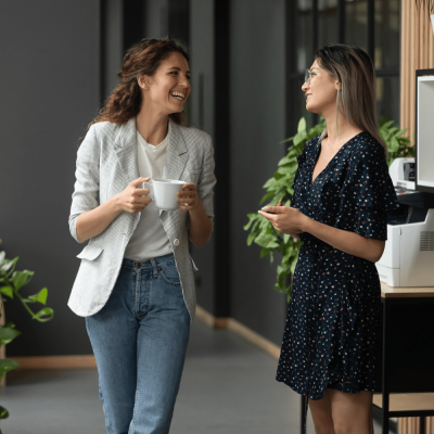 2 vrouwelijke collega's lachend in gesprek